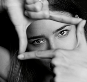 Woman's face seen through her hands making a frame